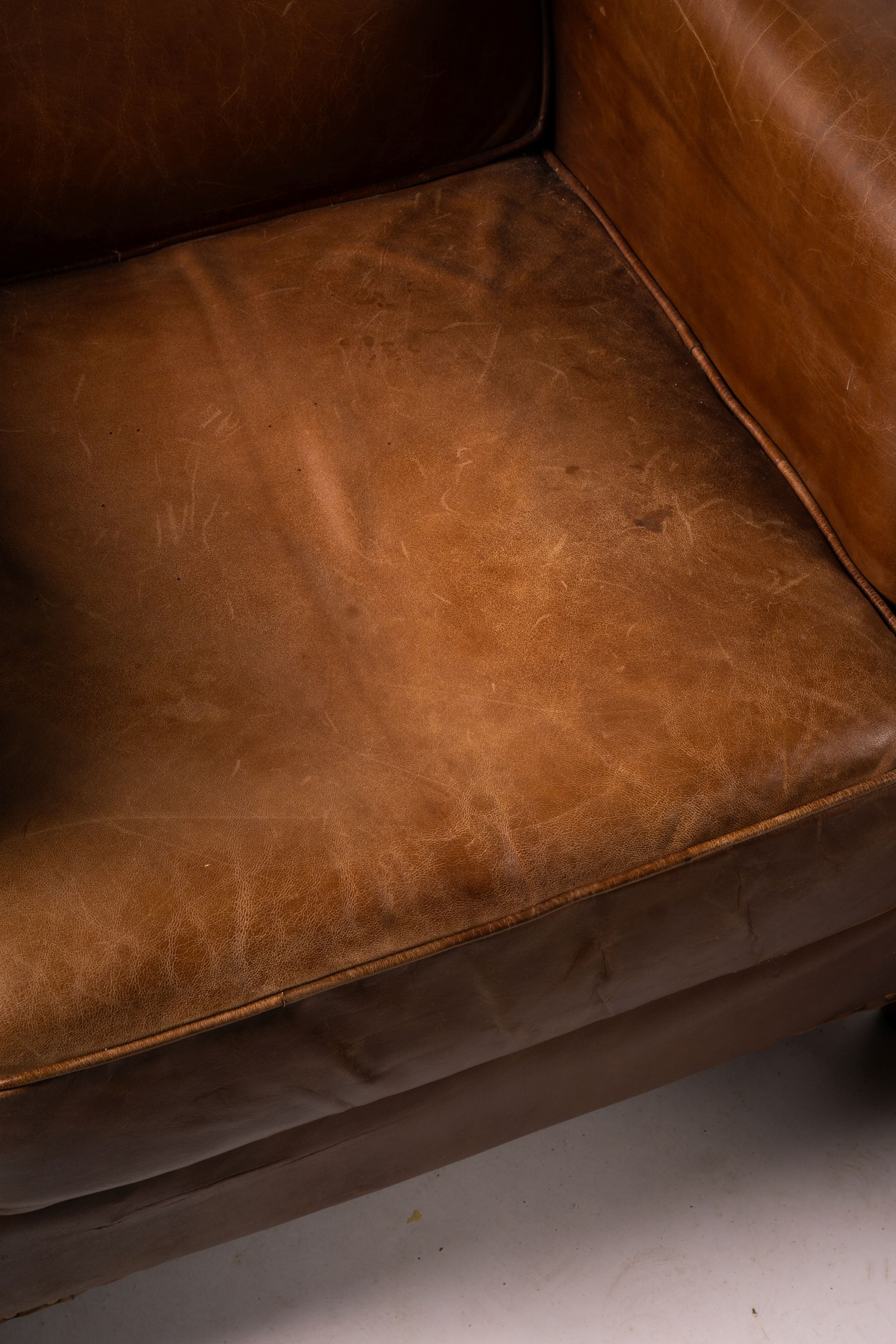 A pair of brown leather club armchairs, width 96cm, depth 80cm, height 90cm